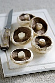 Portobello mushrooms on chopping board