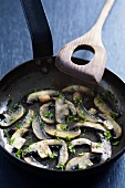 Fried mushrooms with parsley and garlic in frying pan