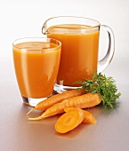 Carrot juice in a glass and a glass jug