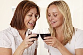 Two women toasting with red wine glasses