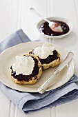 Scones topped with clotted cream and jam