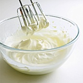 A glass of whipped cream with whisks