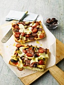 Focaccia pizzas with olives, tomatoes, sausages and ham