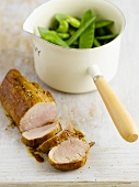 Pork fillet with maple syrup and mange tout in a saucepan