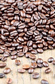 Viele geröstete Kaffeebohnen auf Holzuntergrund