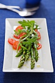 Steamed green asparagus with rocket and tomatoes