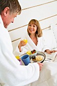 Man bringing a woman breakfast in bed