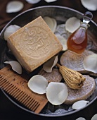 Bowl with soaps, perfume and petals