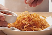 Fried onions being seasoned