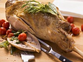 Roast leg of lamb with herb pesto and cherry tomatoes