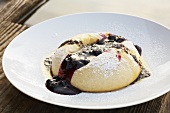 A Dampfnudel (steamed, sweet yeast dumpling) with poppy seed butter and fruit sauce