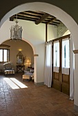 Foyer in a country home with brick arches with a view to an living room (open floor plan)