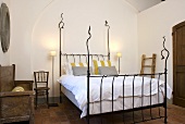 Iron bedstead with white bed linen in a Mediterranean country home