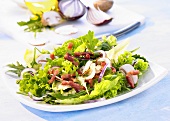 A mixed leaf salad with bacon, mushrooms and onions