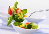 Cooked mixed vegetables on a fork
