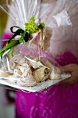 A woman holding homemade meringue biscuits as a gift