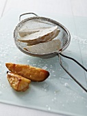 Blanches potatoes being dusted in flour alongside crispy fried potatoes