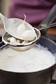 Garlic cloves being cooked in milk