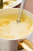 Creamy white wine being foamed with a hand mixer