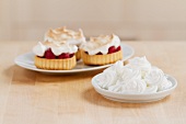 Meringue dots and raspberry tarts topped with meringue