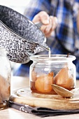 Pouring syrup over poached pears