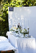 Elegant gedeckter Tisch in Weiß im Garten