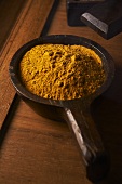 Curry powder in a wooden spoon