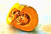 A quarter of a pumpkin with pumpkin seeds
