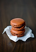 Chocolate macaroons on paper on a dark table