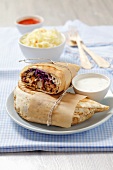 Pita bread filled with chicken, sauce and a cabbage salad