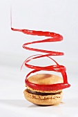 A chocolate macaroon with a spiral of red icing sugar