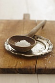 Salt on a ladle on a chopping board
