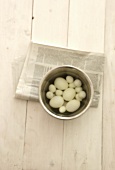 Eggs in a saucepan on a newspaper