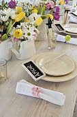 A place setting with a name card on a table set with spring flowers