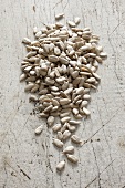 Sunflower seeds on a white wooden surface