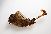 A roasted leg of venison on a white wooden surface