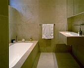 An elegant designer bathroom with light brown floor and wall tiles