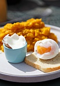 A soft boiled egg on toast with pumpkin puree