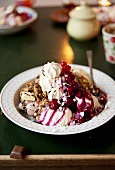 Mixed ice cream with chocolate, fruit sauce and berries