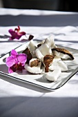 Coconut pieces and an orchid on a plate
