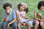 Children eating strawberries and muffins