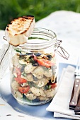 Pasta salad with shell pasta, tomatoes and olives for a picnic