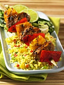 A grilled pork and mango kebab on a bed of couscous