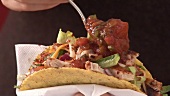 Garnishing taco with fresh coriander