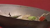 Tossing vegetables and sprouts in a wok