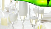 Pouring sparkling wine into four glasses