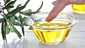 Finger in Olivenöl tauchen