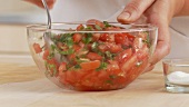 Basilikum und Tomaten vermischen