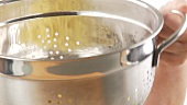 Cooked spaghetti being drained