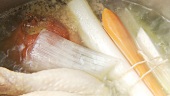 Suppenhuhn mit Zwiebel und Suppengrün köcheln lassen